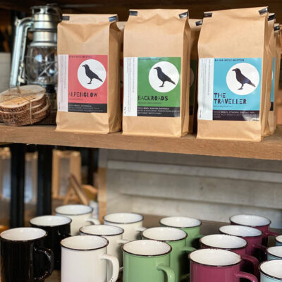Bags of Rifugio coffee on display with mugs in Kelowna, BC