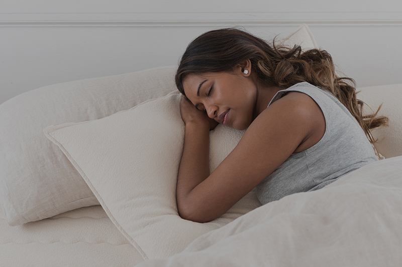 A woman sleeping in bed with her head resting on a pillow